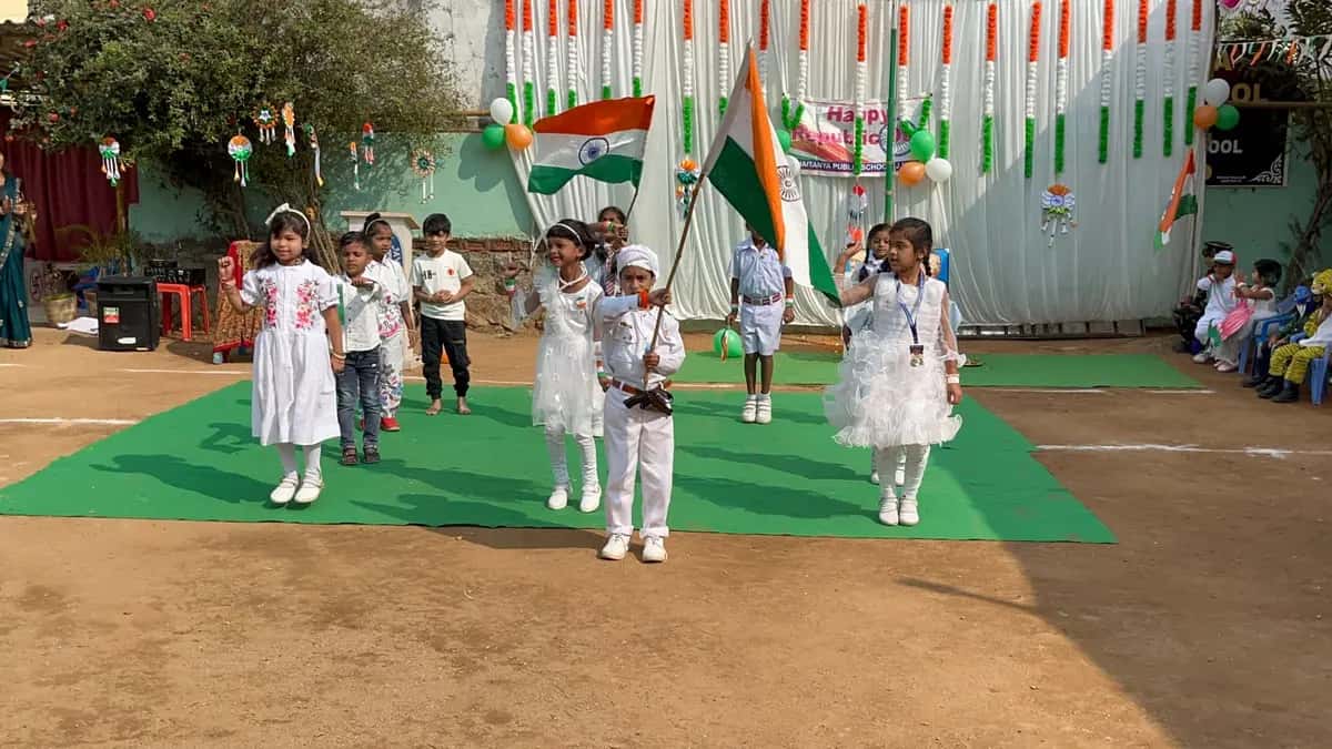 Students performing a dance on the tricolour-decorated school ground